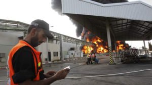 Palestinian firefighters participate in efforts to put out a fire at Gaza's main power plant, which witnesses said was hit in Israeli shelling, in the central Gaza Strip